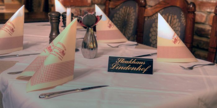 Gedeckter Tisch mit einem Schild wo "Steakhaus Lindenhof" drauf steht